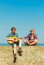 Young man playing guitar to his girlfriend outdoor Royalty Free Stock Photo