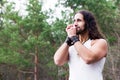 Young man playing the harmonica in a forest glade. Royalty Free Stock Photo
