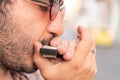 Young man playing harmonica standing on the street Royalty Free Stock Photo