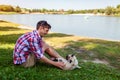 Young man playing with pug dog sitting on grass. Happy puppy having fun with master Royalty Free Stock Photo