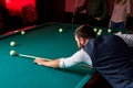 young man playing snooker, lining to hit ball on pool billiards table Royalty Free Stock Photo