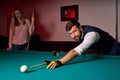 young man playing snooker, lining to hit ball on pool billiards table Royalty Free Stock Photo