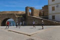 Young man playing soccer in a square close to the walls of the fortress of the Portuguese City Cite Portugaise in the town of El