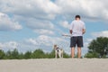 Young man is playing stick pull game with his fow terrier dog at the beach Royalty Free Stock Photo