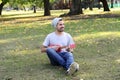 Young man playing the ukelele in a park. Royalty Free Stock Photo