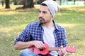 Young man playing the ukelele in a park. Royalty Free Stock Photo