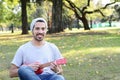 Young man playing the ukelele in a park. Royalty Free Stock Photo
