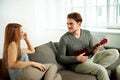 Young man playing ukulele to his girlfriend Royalty Free Stock Photo