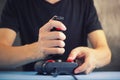 Young man playing video game with a retro joystick