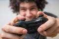 Young man is playing video games and holds joystick or controller Royalty Free Stock Photo