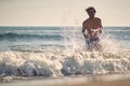 A young man playing in the waves on the beach. Summer, beach, sea, vacation Royalty Free Stock Photo