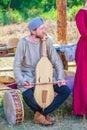 A young man plays an ancient stringed instrument. Military history festival `Military case