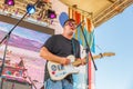 A young man plays the guitar on the open summer stage Royalty Free Stock Photo