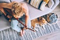 Young man plays on guitar sitting on sofa and beagle dog listen Royalty Free Stock Photo