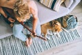 Young man plays on guitar sitting on sofa in cozy home atmosphere. Beagle dog lies near on the floor Royalty Free Stock Photo