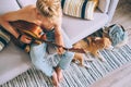 Young man plays on guitar sitting on sofa in cozy home atmosphere Royalty Free Stock Photo