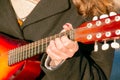 A young man plays the mandolin in the city on the street. Close-up hands