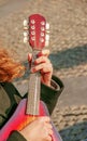 A young man plays the mandolin in the city on the street. Close-up hands