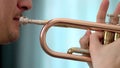 A young man plays the trumpet. Hands of musician. Close up view