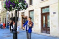 A young man plays the violin on a historic street in Lvov. The musician violinist performs classical music for tourists Royalty Free Stock Photo