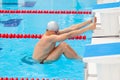 Young man in a pool - go to start swimming. backstroke during