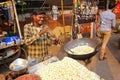 Young man popping popcorn at Kinari Bazaar in Agra, Uttar Pradesh, India