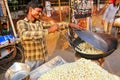Young man popping popcorn at Kinari Bazaar in Agra, Uttar Pradesh, India