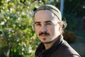 Young man portrait with beard,earlocks, sidelocks and moustache at sunny day outdoors . Happy smiling person looking adorable