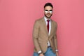 Young man posing against pink background with attitude