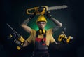 A young man posing on a black background in a work uniform and a construction tool power saw Royalty Free Stock Photo