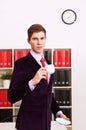 Young man posing with coffee cup in office Royalty Free Stock Photo