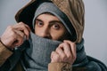 Young man posing in hat, scarf and hood, isolated on grey Royalty Free Stock Photo