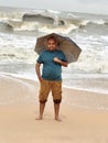 A young man at the Kundapura beach with an umbrella Royalty Free Stock Photo