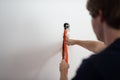 Young man positioning orange corrugated electrical tube into a wall