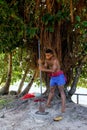 Young man pounding kava roots in Lavena village, Taveuni Island, Fiji Royalty Free Stock Photo