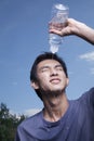 Young Man Pouring Bottled Water Over His Head