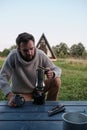 Young man pours coffee from a geyser coffee maker