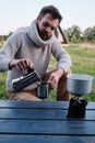 Young man pours coffee from a geyser coffee maker Royalty Free Stock Photo