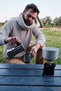 Young man pours coffee from a geyser coffee maker Royalty Free Stock Photo