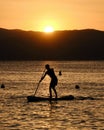 Young man practicing paddle surf during the sunset