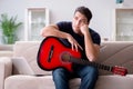 The young man practicing playing guitar at home Royalty Free Stock Photo