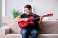 The young man practicing playing guitar at home Royalty Free Stock Photo
