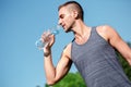 Healthy Lifestyle. Man practicing yoga outdoors standing with bottle dinking water thirsty bottom view Royalty Free Stock Photo