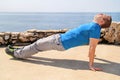 A young man practicing yoga, pilates and stretching on a seashore. Handsome man is doing stretching exercises on the beach. Royalty Free Stock Photo