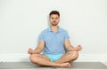 Young man practicing zen yoga near wall Royalty Free Stock Photo