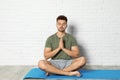 Young man practicing zen yoga near  brick wall Royalty Free Stock Photo