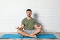 Young man practicing zen yoga near white wall Royalty Free Stock Photo