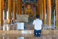 Young man in prayer in front of Buddha, Cambodia