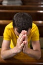 Young man praying in a church Royalty Free Stock Photo