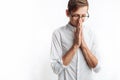 A young man praying to God or Jesus Christ, folded, on a white background, asking for help Royalty Free Stock Photo